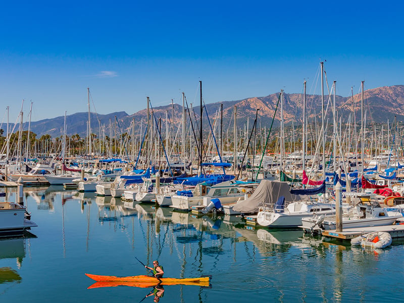 a marina with many boats and a mountain range in the background